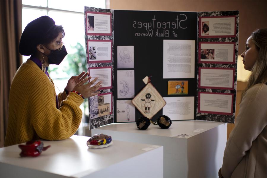 A student explains their research at undergraduate research day.