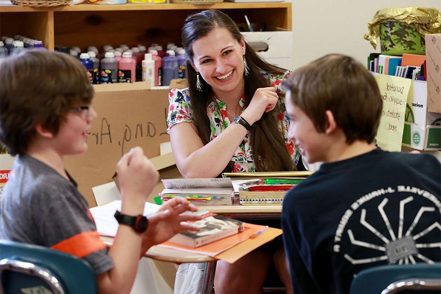 A teacher works with two young students.