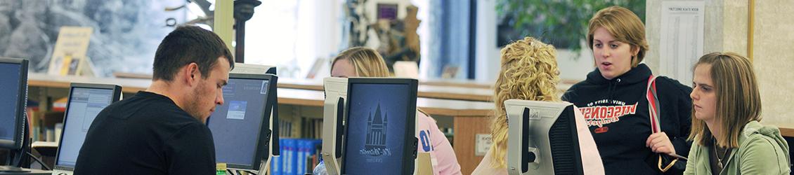 Dean of Students with students studying at the library