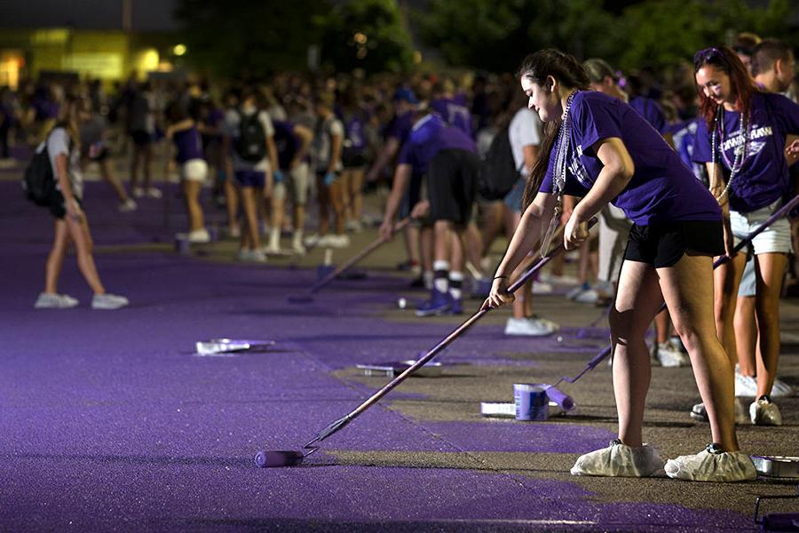 Students paiting the road purple for homecoming