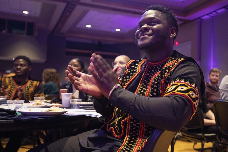 An international student from Nigeria claps during a performance in the University Center.