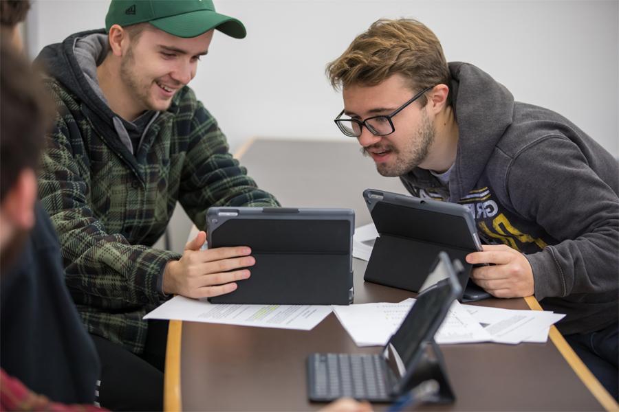 Two students look at a tablet.